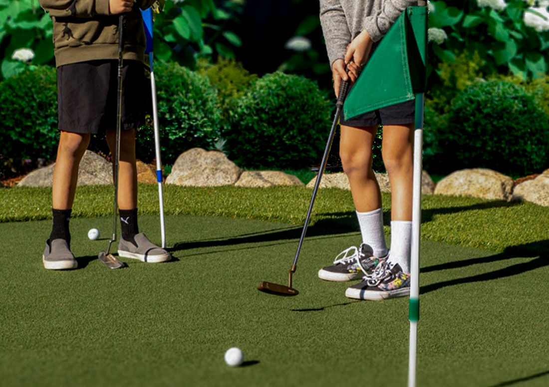 Kids Putting on artificial grass putting green