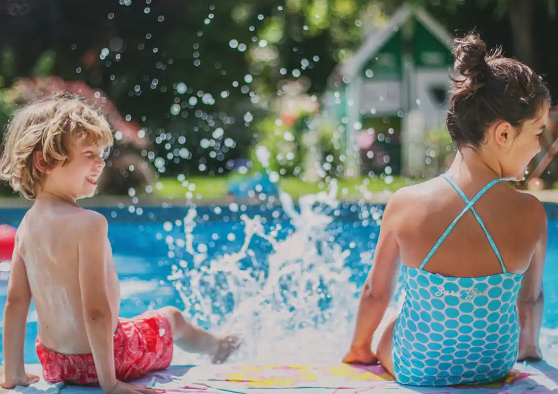 kids playing around pool with artificial turf installed